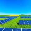 Peisaj verde cu panouri solare și câmpuri agricole.