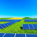 Peisaj verde cu panouri solare și câmpuri agricole.